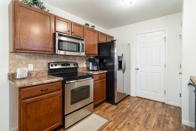 kitchen featuring dark hardwood / wood-style flooring, decorative backsplash, and stainless steel appliances