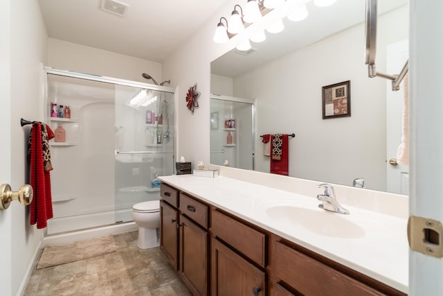 bathroom featuring vanity, an enclosed shower, and toilet