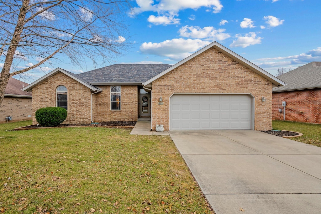 ranch-style house featuring a garage and a front yard