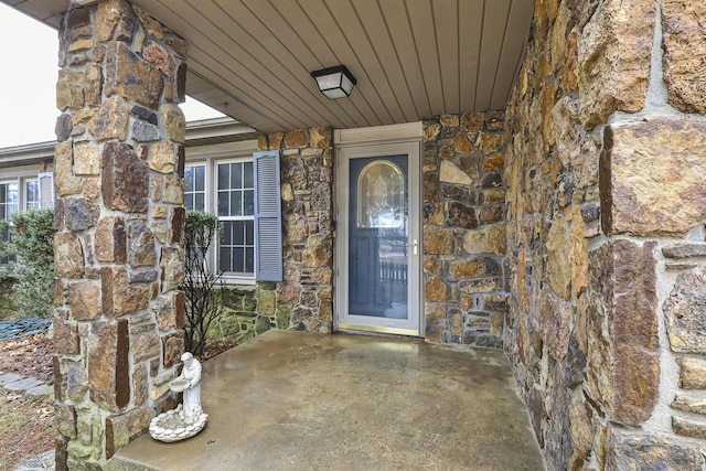 view of exterior entry with a patio area