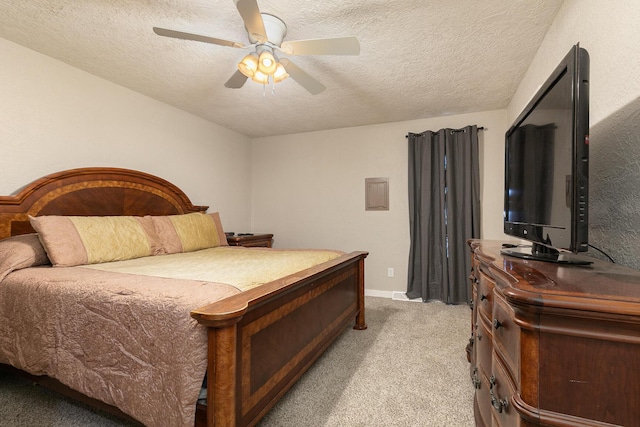 carpeted bedroom with ceiling fan and a textured ceiling