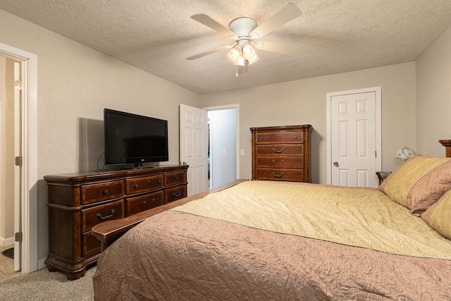 carpeted bedroom with ceiling fan and a textured ceiling