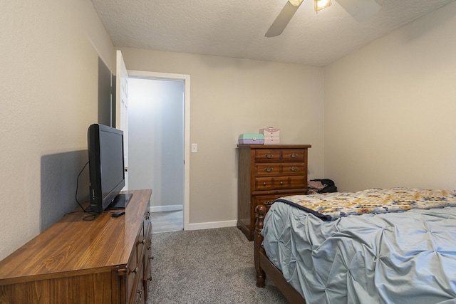 bedroom with ceiling fan, carpet floors, and a textured ceiling