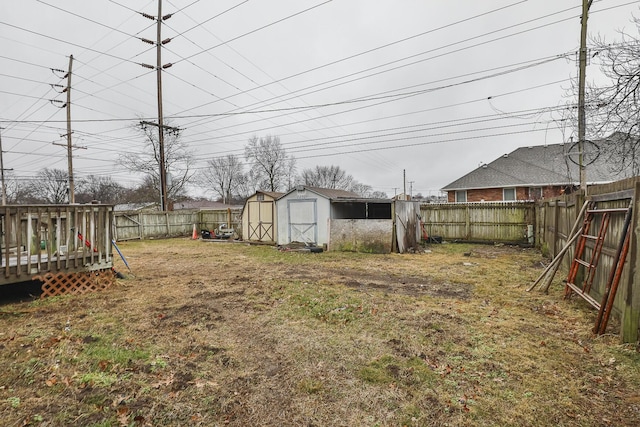 view of yard featuring a wooden deck and a storage shed