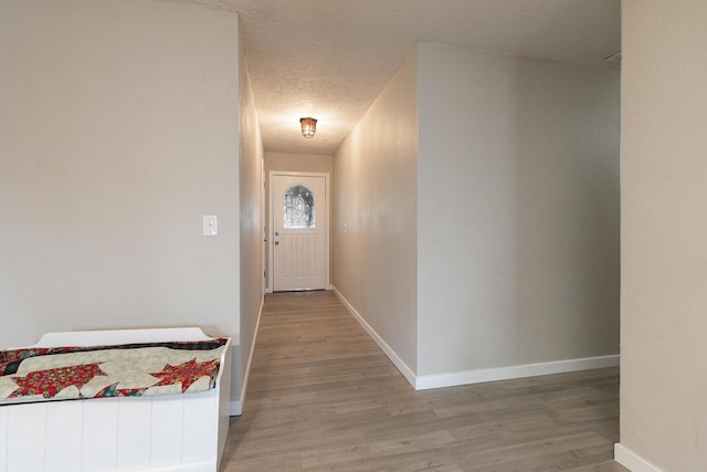 doorway to outside with hardwood / wood-style flooring and a textured ceiling