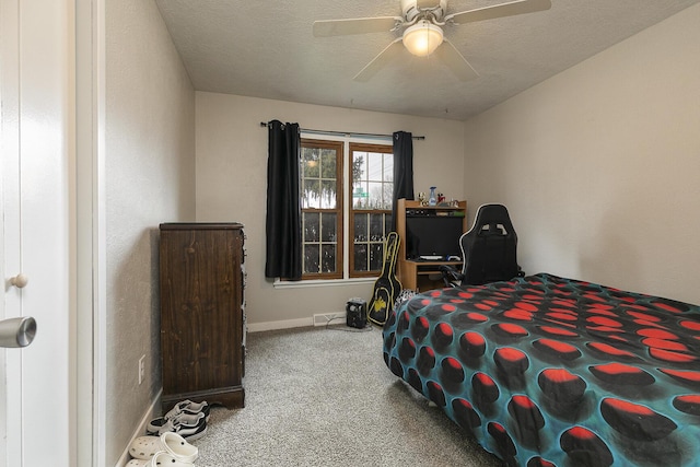 carpeted bedroom with ceiling fan and a textured ceiling