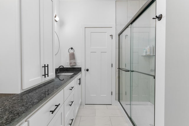 bathroom with vanity and a shower with door