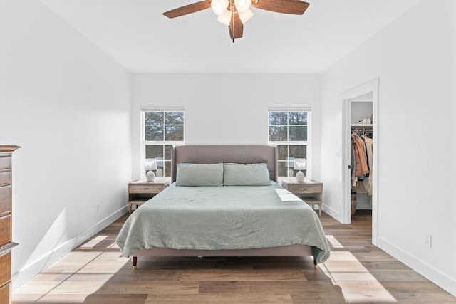 bedroom featuring hardwood / wood-style flooring, a spacious closet, ceiling fan, and a closet