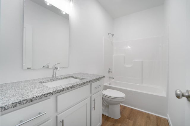 full bathroom featuring shower / washtub combination, hardwood / wood-style floors, vanity, and toilet