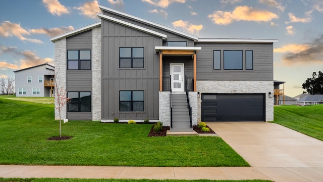 contemporary home with a garage and a lawn