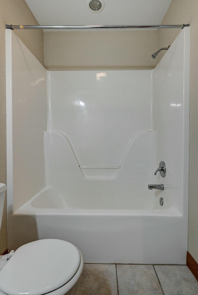 bathroom featuring shower / bathtub combination, tile patterned floors, and toilet