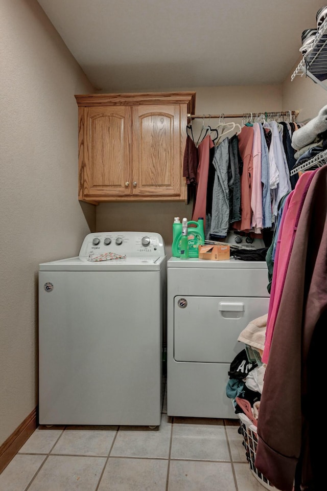 washroom featuring cabinets, separate washer and dryer, and light tile patterned floors