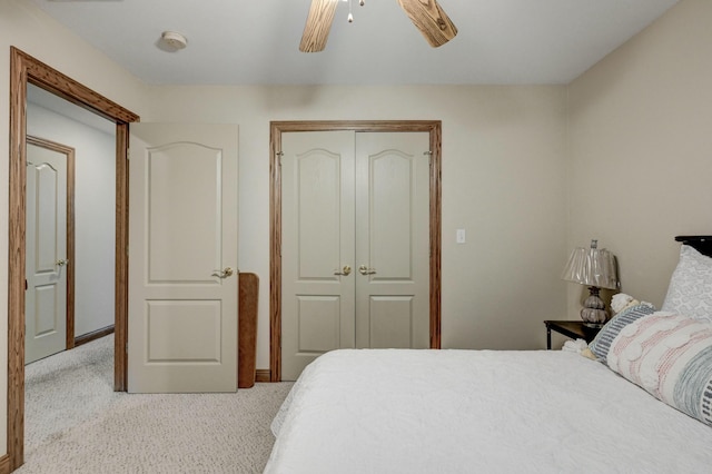 bedroom featuring light carpet, ceiling fan, and a closet