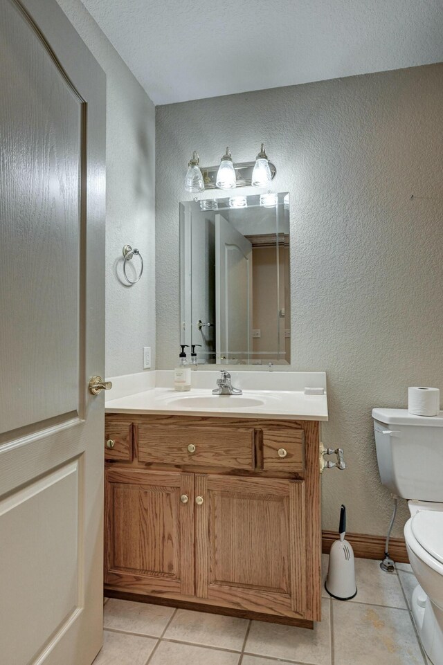 bathroom with tile patterned flooring, vanity, and toilet