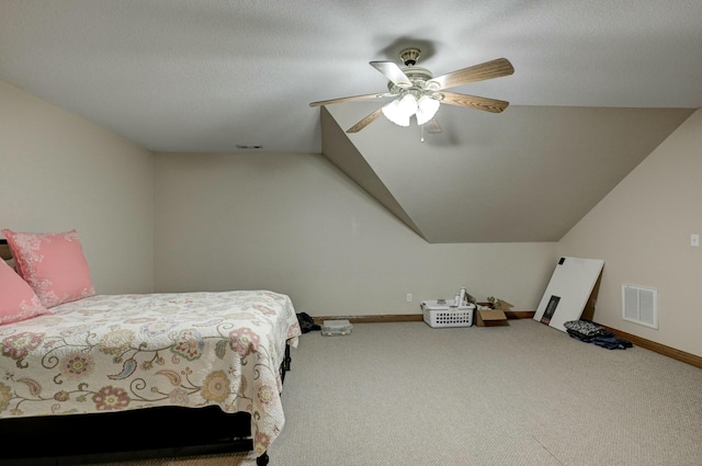 carpeted bedroom featuring vaulted ceiling, a textured ceiling, and ceiling fan