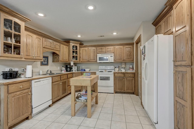 kitchen featuring white appliances, sink, and light tile patterned floors