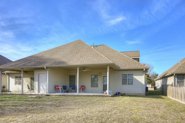 rear view of property featuring ceiling fan, a patio area, and a lawn