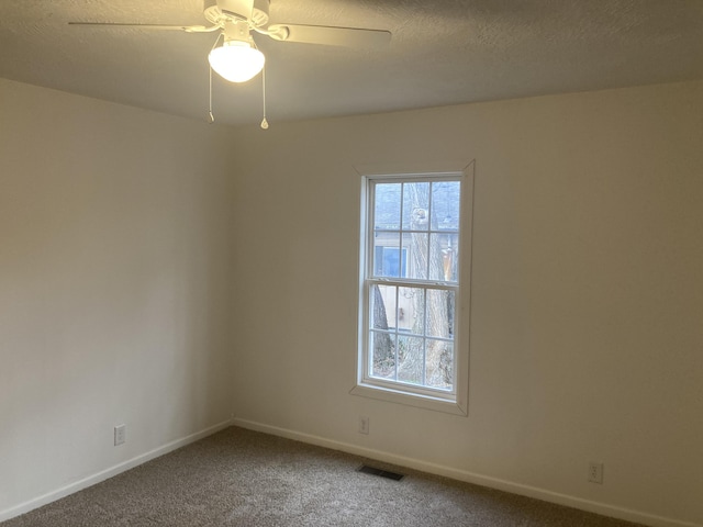 unfurnished room featuring carpet, plenty of natural light, a textured ceiling, and ceiling fan