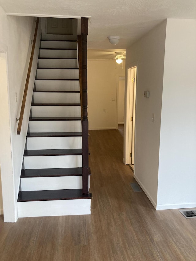 stairway featuring hardwood / wood-style flooring and ceiling fan