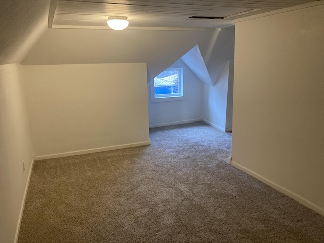 bonus room with lofted ceiling and carpet floors