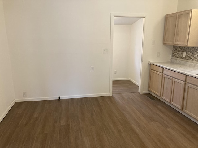 kitchen featuring dark hardwood / wood-style floors, light brown cabinets, and decorative backsplash