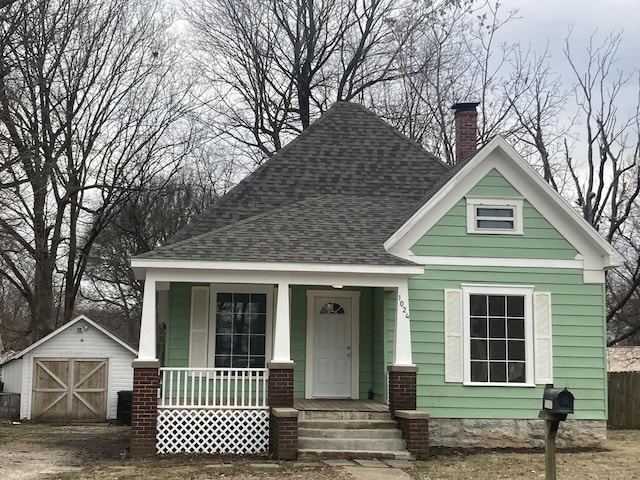 view of front of property with a porch and a shed