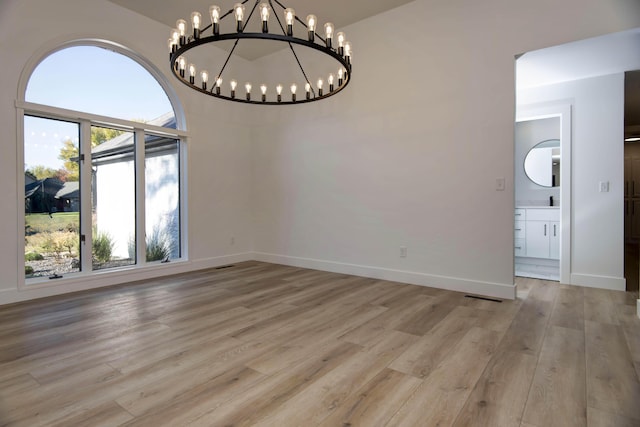 unfurnished dining area with a notable chandelier and light wood-type flooring