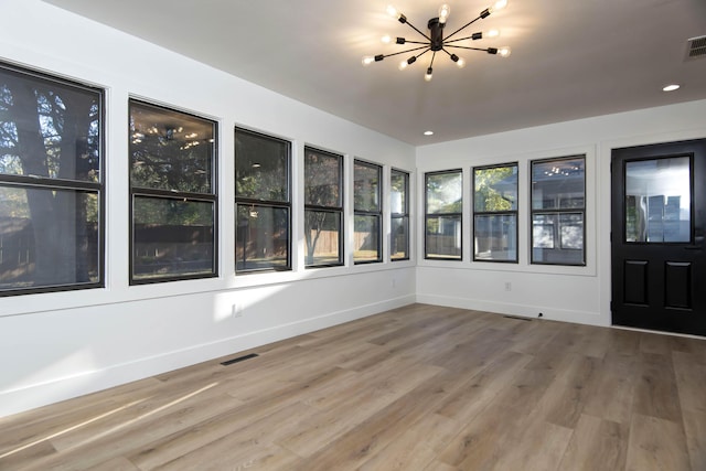 unfurnished sunroom featuring an inviting chandelier