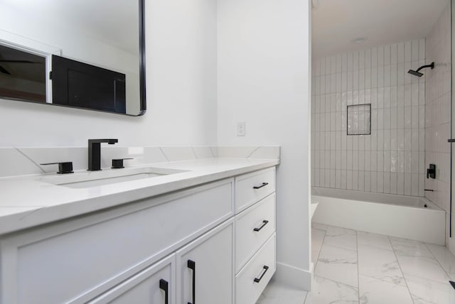 full bathroom featuring tiled shower / bath, vanity, and toilet