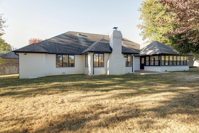 rear view of house with a yard and a sunroom