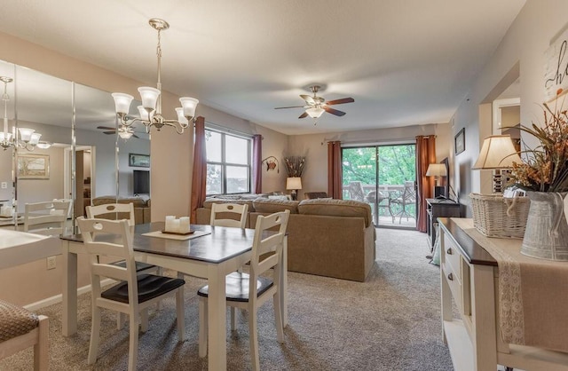 dining space with light carpet and ceiling fan with notable chandelier