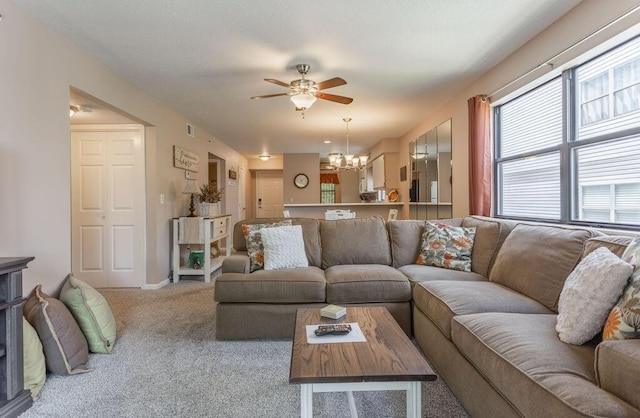 living room with ceiling fan with notable chandelier and carpet floors