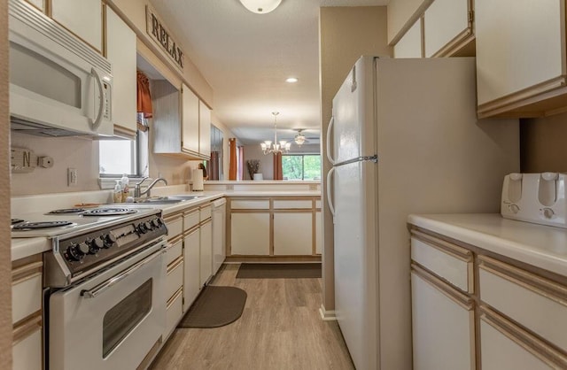 kitchen with sink, light wood-type flooring, kitchen peninsula, a notable chandelier, and white appliances