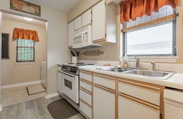 kitchen with white cabinetry, sink, white appliances, and light wood-type flooring