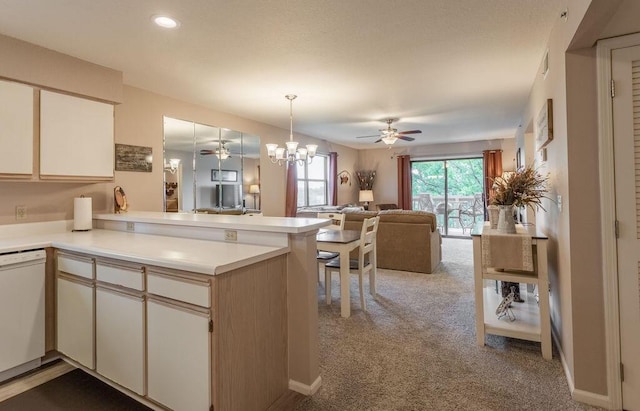 kitchen with light carpet, white dishwasher, kitchen peninsula, pendant lighting, and ceiling fan with notable chandelier