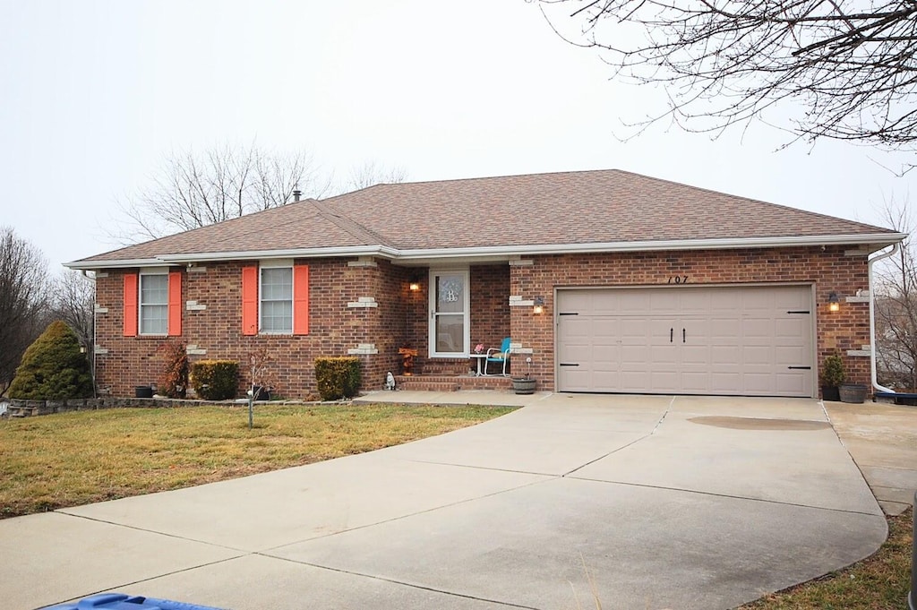 single story home featuring a garage and a front lawn