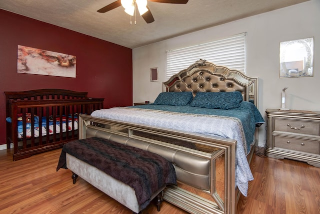 bedroom featuring hardwood / wood-style flooring, ceiling fan, and a textured ceiling