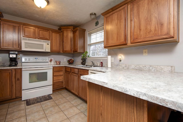 kitchen with white appliances, sink, a textured ceiling, and light tile patterned floors