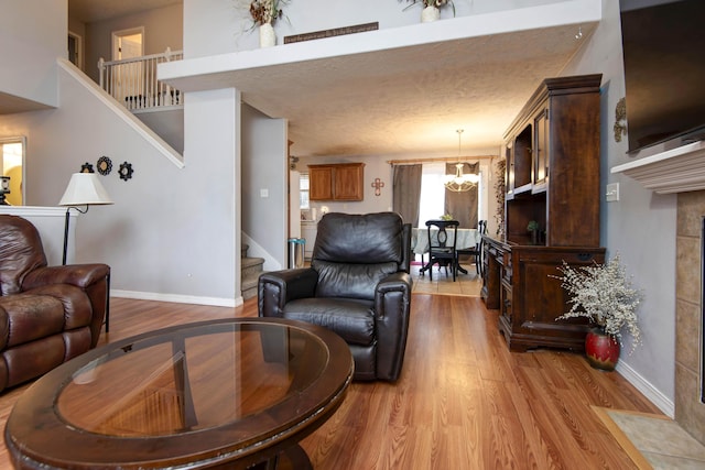 living room featuring a high ceiling, light hardwood / wood-style flooring, and a notable chandelier