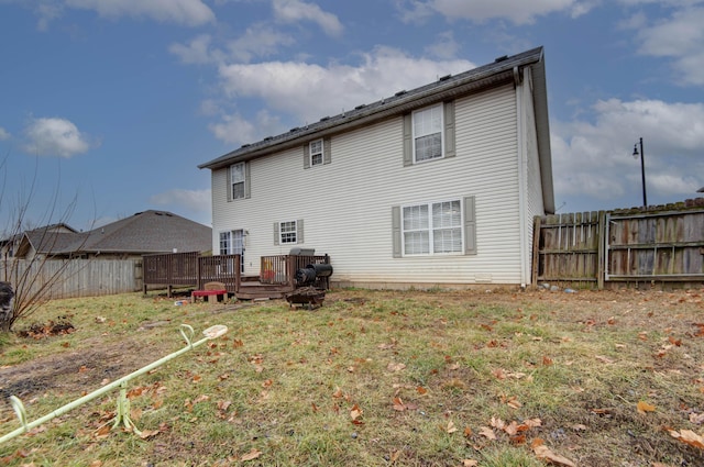 back of property with a wooden deck and a yard