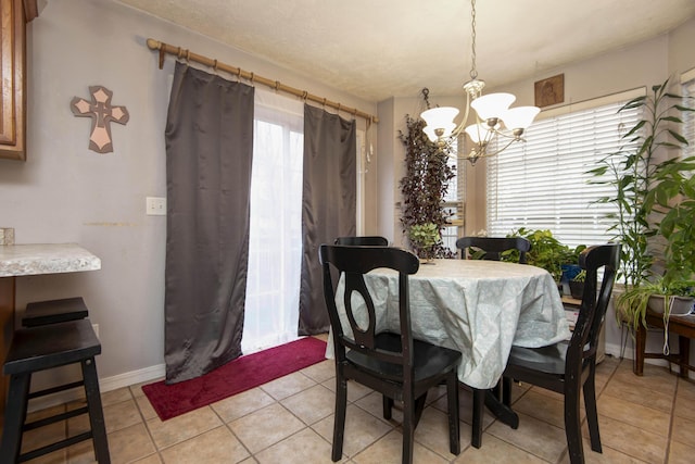 dining area featuring light tile patterned floors and a notable chandelier