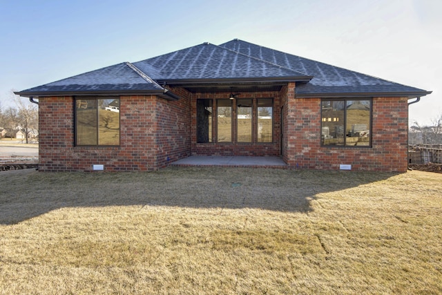 rear view of property featuring a patio and a lawn