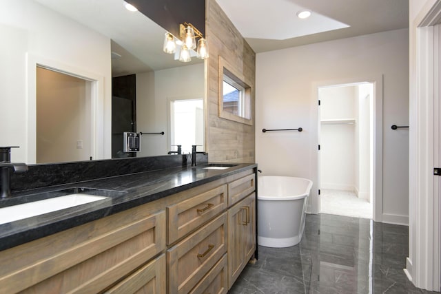 bathroom with vanity, a chandelier, and a bathtub