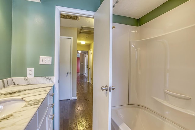 bathroom with wood-type flooring, bathtub / shower combination, and vanity