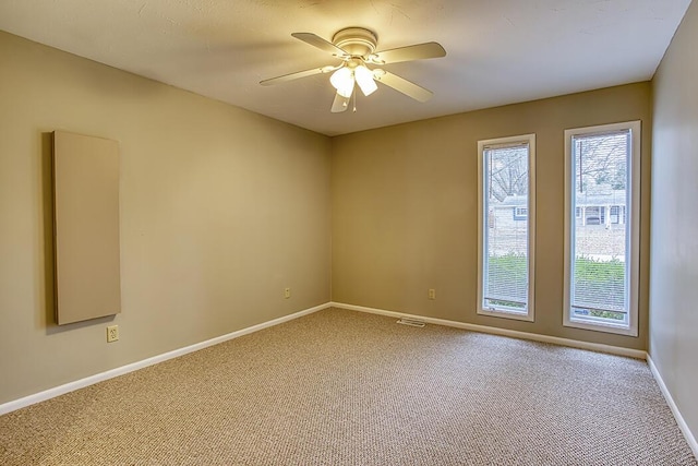 carpeted spare room featuring ceiling fan