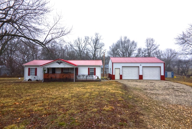 single story home featuring a garage, covered porch, and a front yard