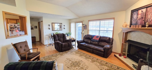 living room with light hardwood / wood-style floors and vaulted ceiling