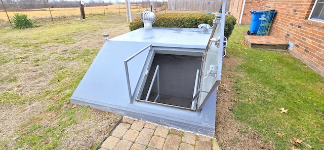 entry to storm shelter with a yard and a rural view