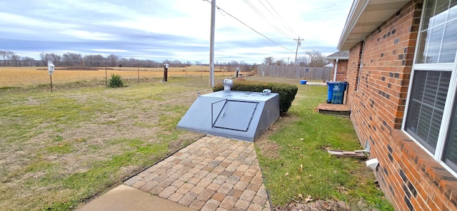 view of storm shelter featuring a rural view and a lawn