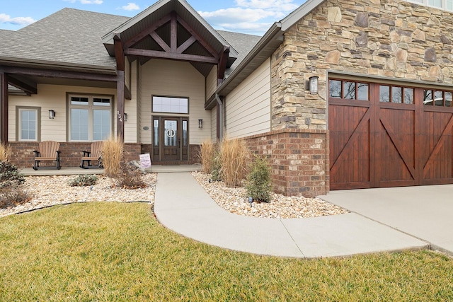 view of exterior entry featuring a garage and a yard